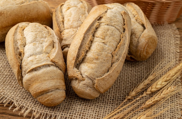 Pão francês integral pão de sal ou pistolet sobre mesa de madeira