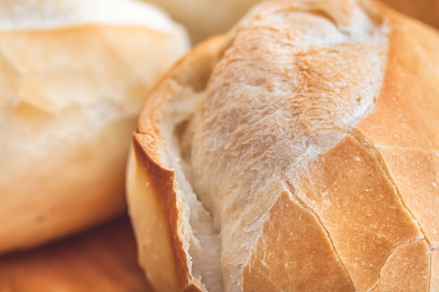 Pão francês na placa de madeira em foto macro