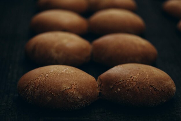 Pão fresco assado e espigas de trigo sobre um fundo de madeira