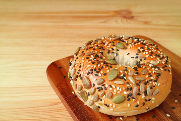 Foto pão fresco com sementes de abóbora, sementes de girassol e gergelim na bandeja de madeira