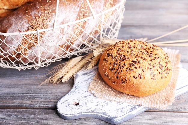 Pão fresco cozido na cesta em fundo de madeira