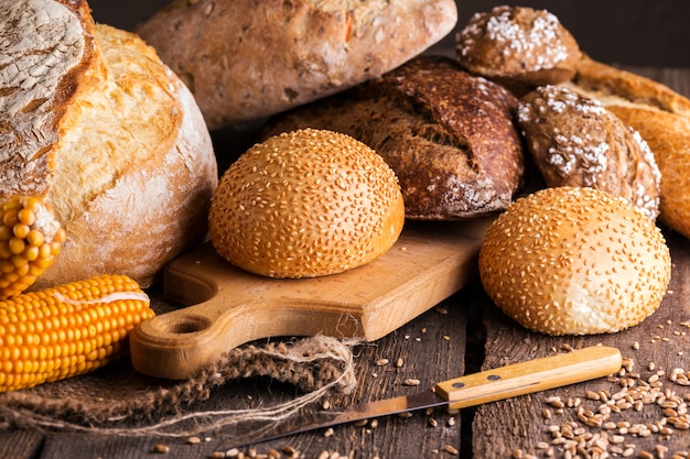 Pão fresco diferente e pãezinhos na mesa de madeira