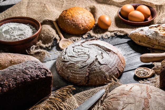 Pão fresco e trigo diferentes na madeira