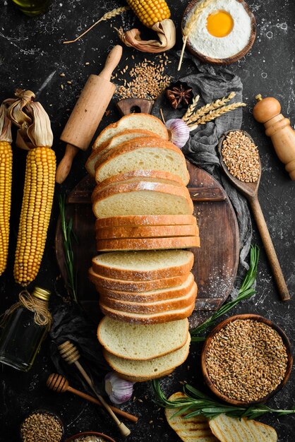 Pão fresco e trigo na velha mesa da cozinha Cozimento de centeio e farinha Vista superior Estilo rústico