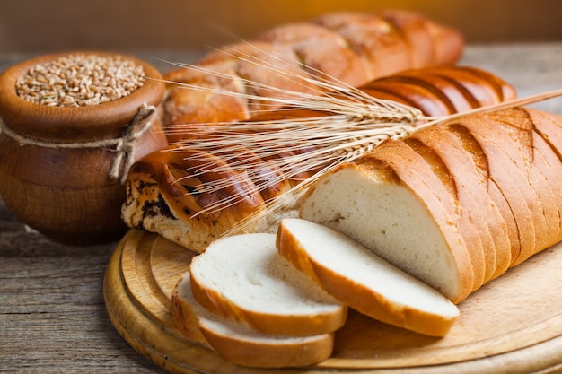 Pão fresco em um fundo antigo com acessórios de cozinha em cima da mesa.