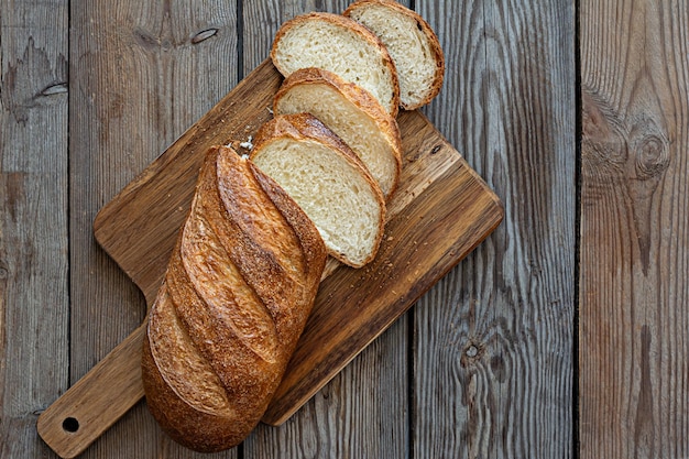 Pão fresco em um fundo marrom. Pão rústico fresco de trigo tradicional, naco de pão.