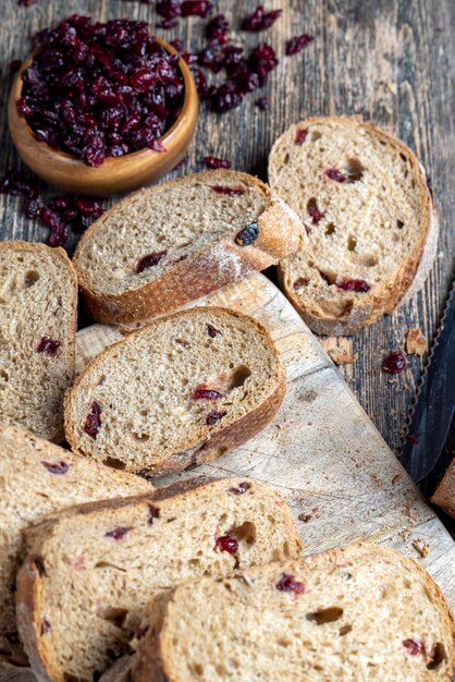 pão fresco feito de farinha e cranberries secas, bagas de cranberry vermelhas em pão cortado em pedaços