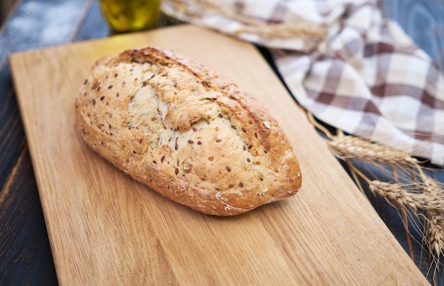 Pão fresco na tábua de madeira na mesa da cozinha