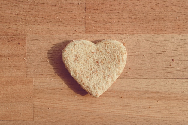 Pão granulado cortado em forma de coração. Conceito de amor e carinho no dia dos namorados.