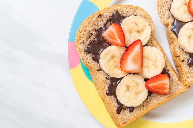 pão integral torrado com banana fresca, morango e chocolate no café da manhã