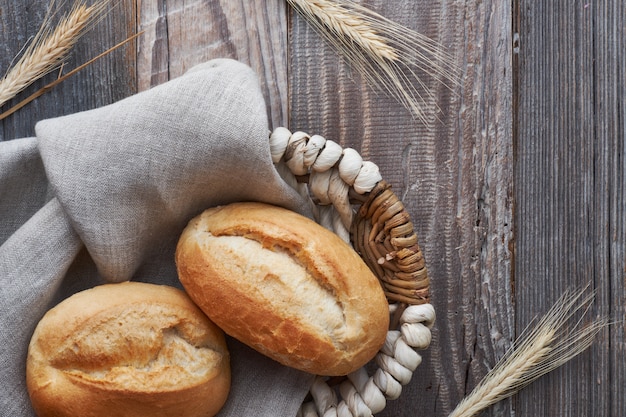 Pão na cesta de madeira rústica com espigas de trigo