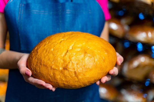 Pão nas mãos de um padeiro Assar a quente do forno Produção industrial de pão Mãos de padeiro com pão