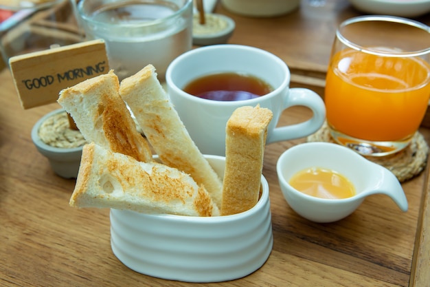 Pão no café da manhã com chá e suco de laranja
