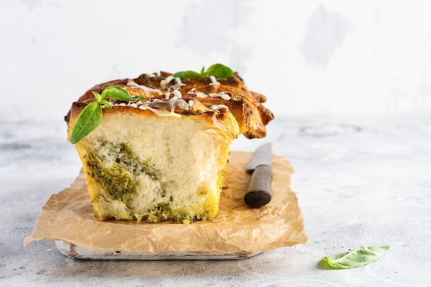 Pão para separar com pesto de massa italiana, manjericão e queijo parmesão assado sobre concreto velho