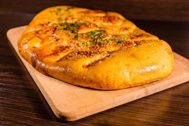 Pão pita com alho em uma tábua de madeira