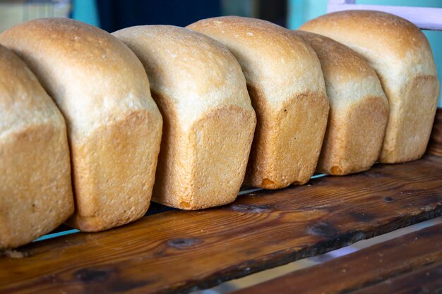 Pão quente e recém-cozido é colocado em bandejas na padaria