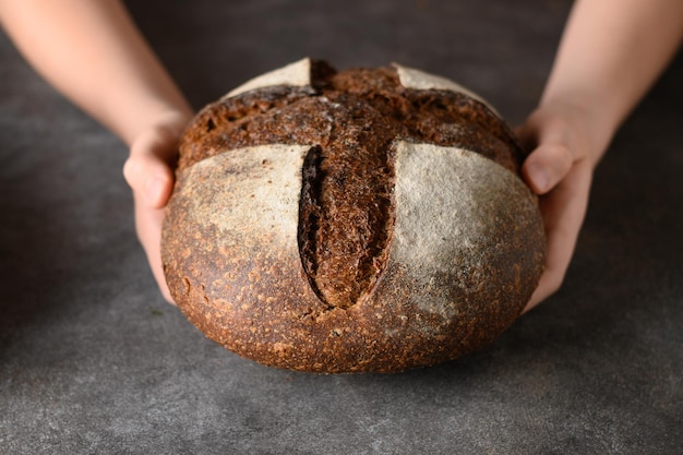 Pão recém-assado com farinha de cânhamo nas mãos