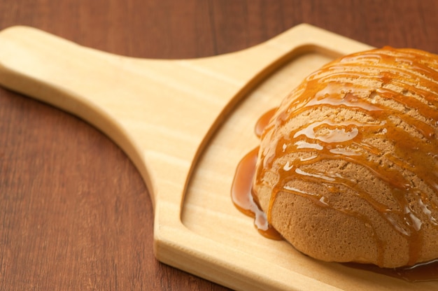 Pão regado com mel na placa de madeira closeup