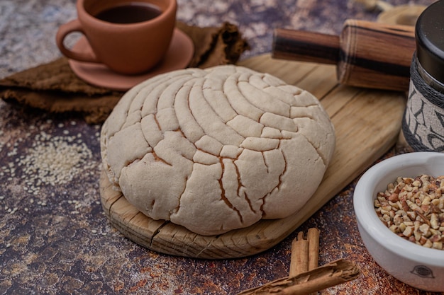 Pão rústico caseiro doce em uma mesa, complementado com uma xícara de café, peça de padaria tradicional