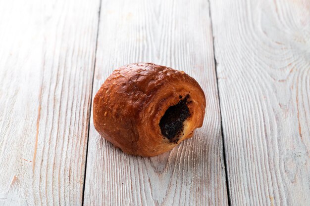 Pão saboroso recém-assado em uma mesa de madeira branca Produtos assados saborosos direto da padaria