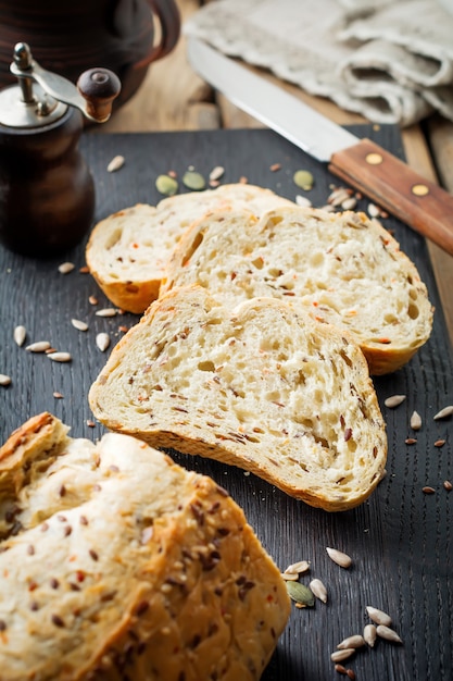 Pão saudável com farelo, sementes de girassol, abóbora, sementes de linho e gergelim em uma velha superfície de madeira