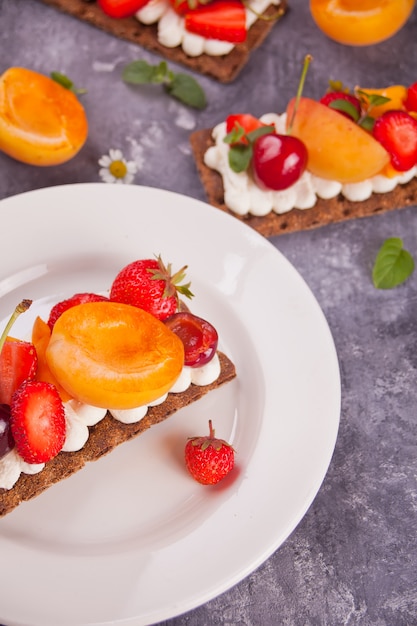 Pão torrado com cream cheese, frutas e bagas