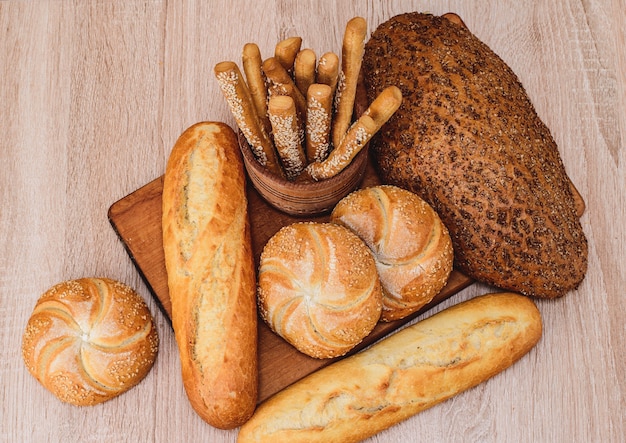 Pão torrado com pãezinhos baguetes francesas de raças diferentes em fundo de madeira