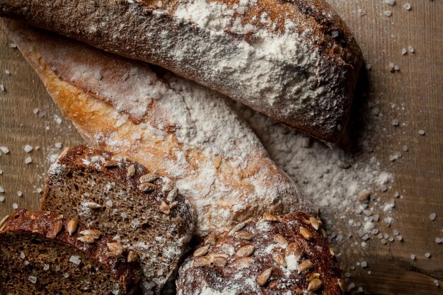 Pão tradicional recém-assado com farinha na baguete fresca de mesa de madeira com farinha