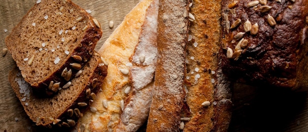 Pão tradicional recém-assado com sementes de girassol na mesa de madeira baguete fresca com sal