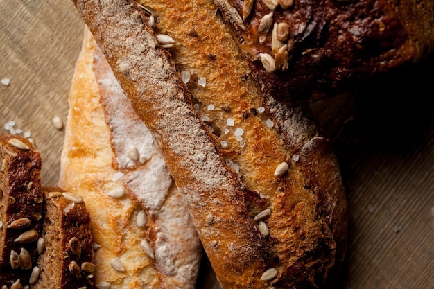 Pão tradicional recém-assado com sementes de girassol na mesa de madeira baguete fresca com sal