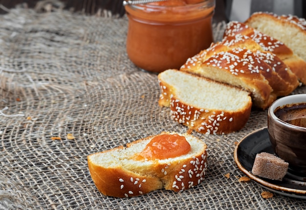 Pão trançado doce fatiado, café e geléia