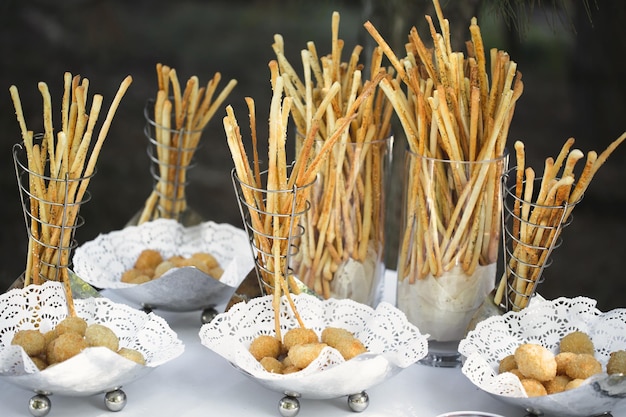 Pãozinho e salgadinhos na mesa do bufê.