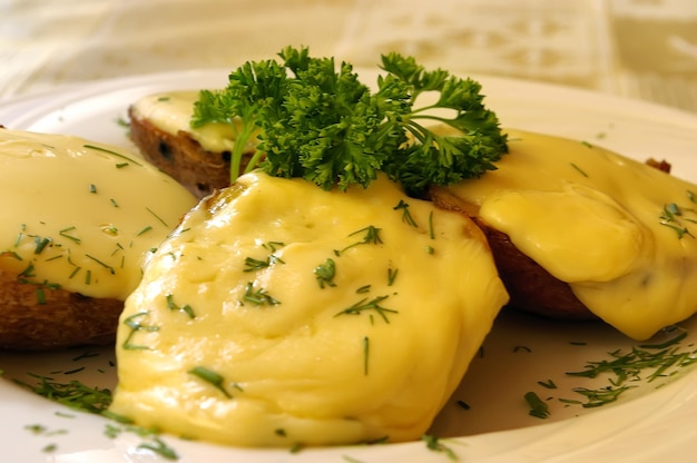 La papa al horno con queso decorada con perejil en el restaurante