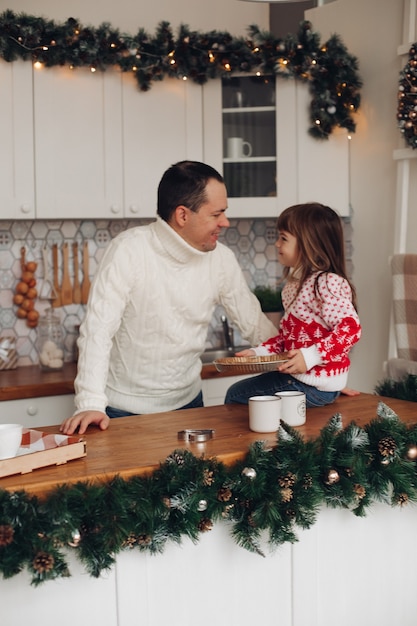 Papá amoroso feliz con su linda hija en Navidad