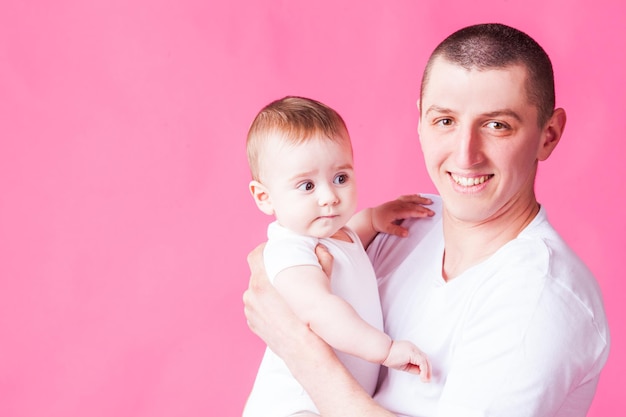 Papá y bebé aislado sobre fondo rosa