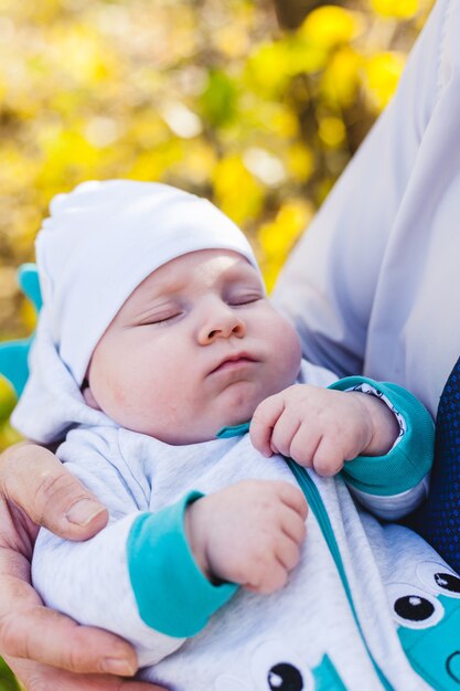 Papá con un bebé, un niño pequeño camina en el otoño en el parque o el bosque. Hojas amarillas, la belleza de la naturaleza. Comunicación entre un niño y un padre.