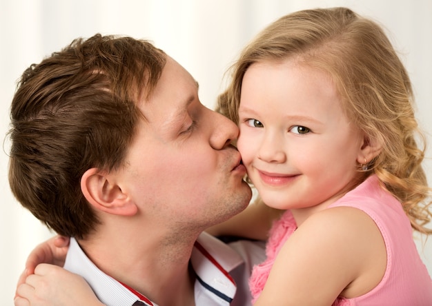 Papá besando a la pequeña hija hermosa