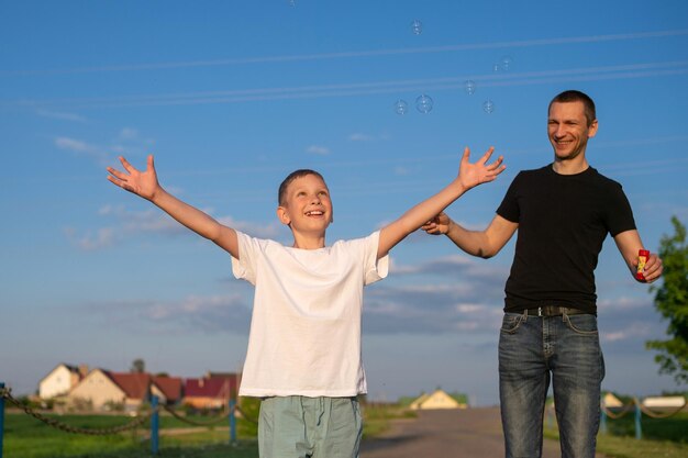 Papa bläst Seifenblasen, emotionaler Junge fängt sie auf