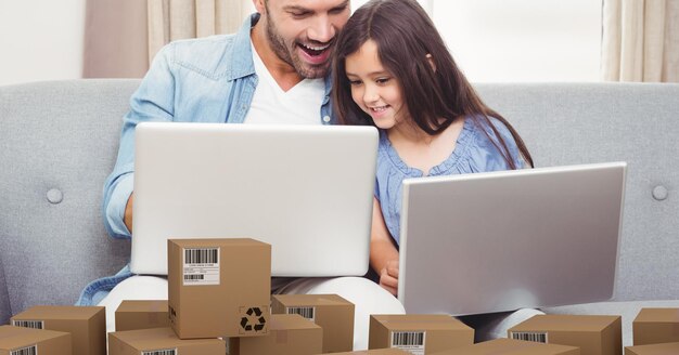 Papá caucásico y su hija usando laptop comprando en línea con un montón de cajas