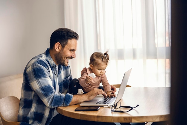 Papá, en cooperación con su hija, está terminando el informe para trabajar desde casa