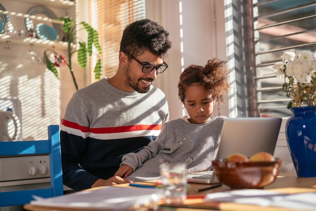 Papá e hija aprendiendo juntos en una computadora.