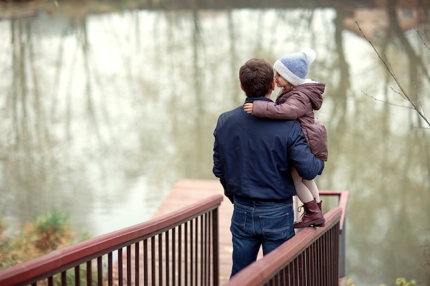 Papá e hija pasan tiempo juntos junto al lago en la naturaleza.