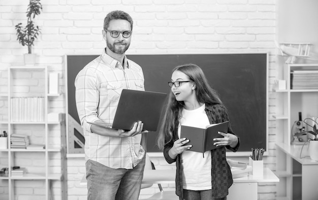 Papá e hija usan cuaderno de regreso a la escuela educación infantil alumno curioso y tutor