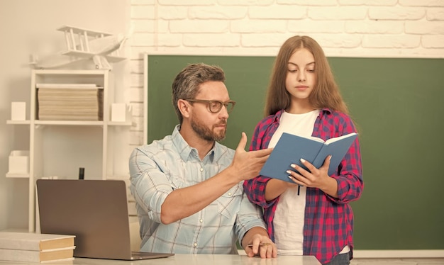 Papá e hija usan cuaderno de regreso a la escuela educación infantil concentrado alumno y tutor