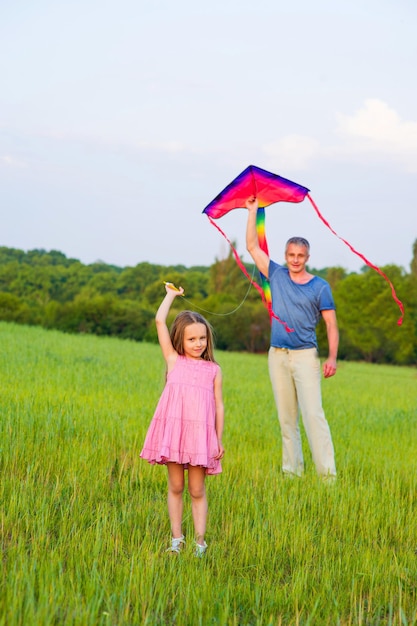 Papá e hija vuelan una cometa.