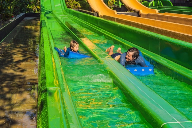 Papá e hijo se divierten en el parque acuático.