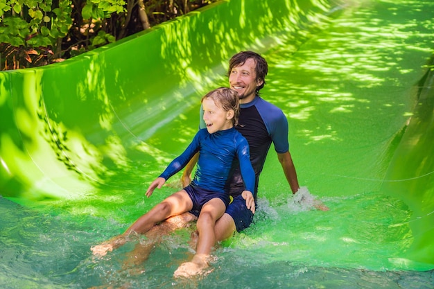 Papá e hijo se divierten en el parque acuático.