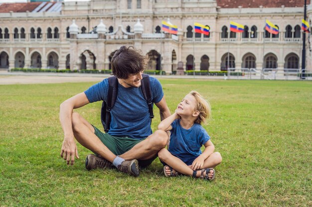 Papá e hijo en el fondo de la plaza Merdeka y el edificio Sultan Abdul Samad Viajando con el concepto de niños