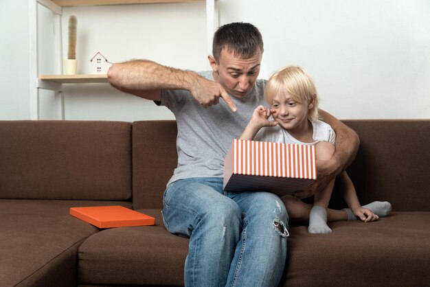 Papá e hijo jóvenes miran sorprendidos una caja de regalo abierta