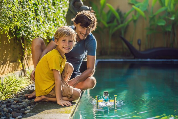 Papá e hijo jugando con un bote en la piscina